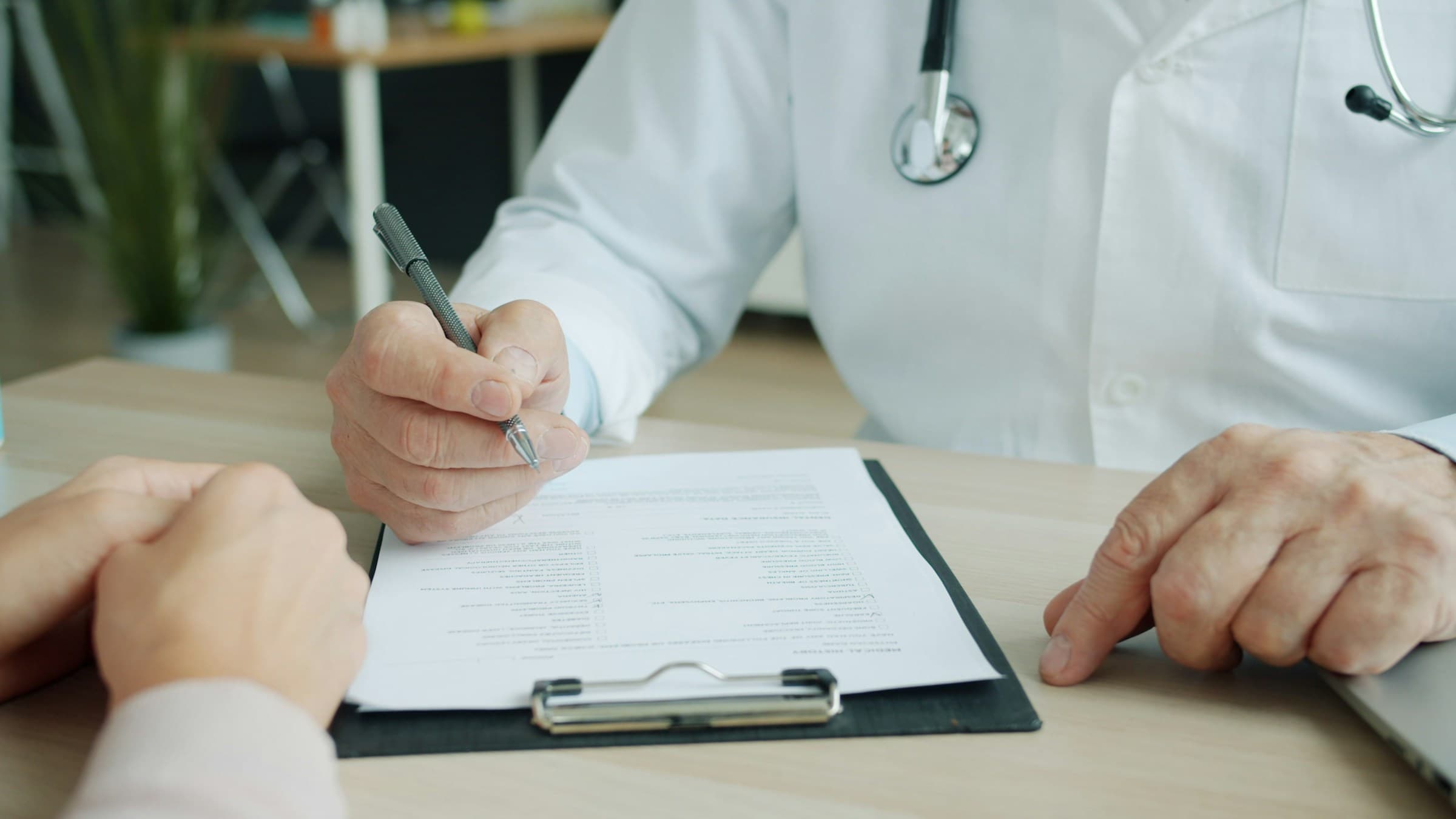 Anamnesegespräch: Arzt und Patient besprechen einen Befundbogen
